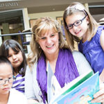 Woman reading to several younger children